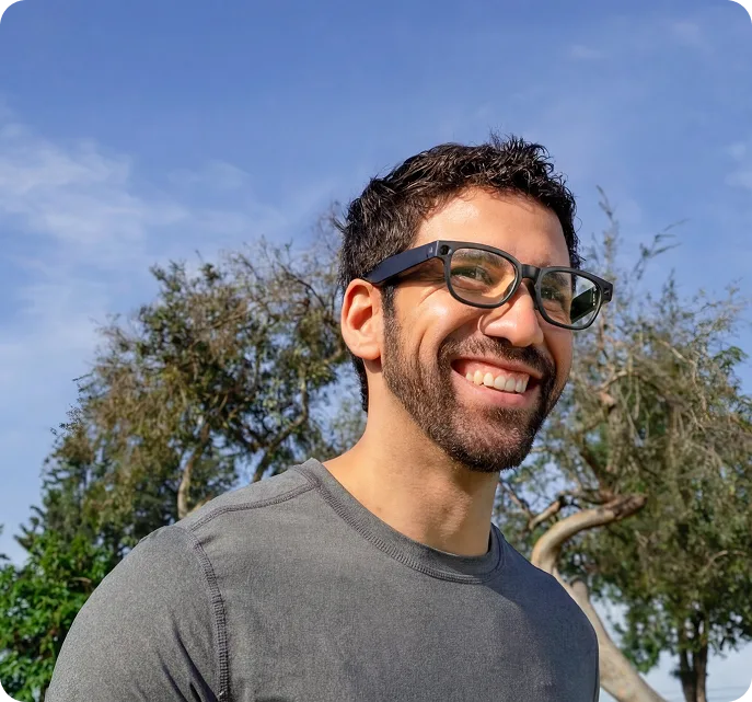 Man wearing Mentra Live smart glasses in a park