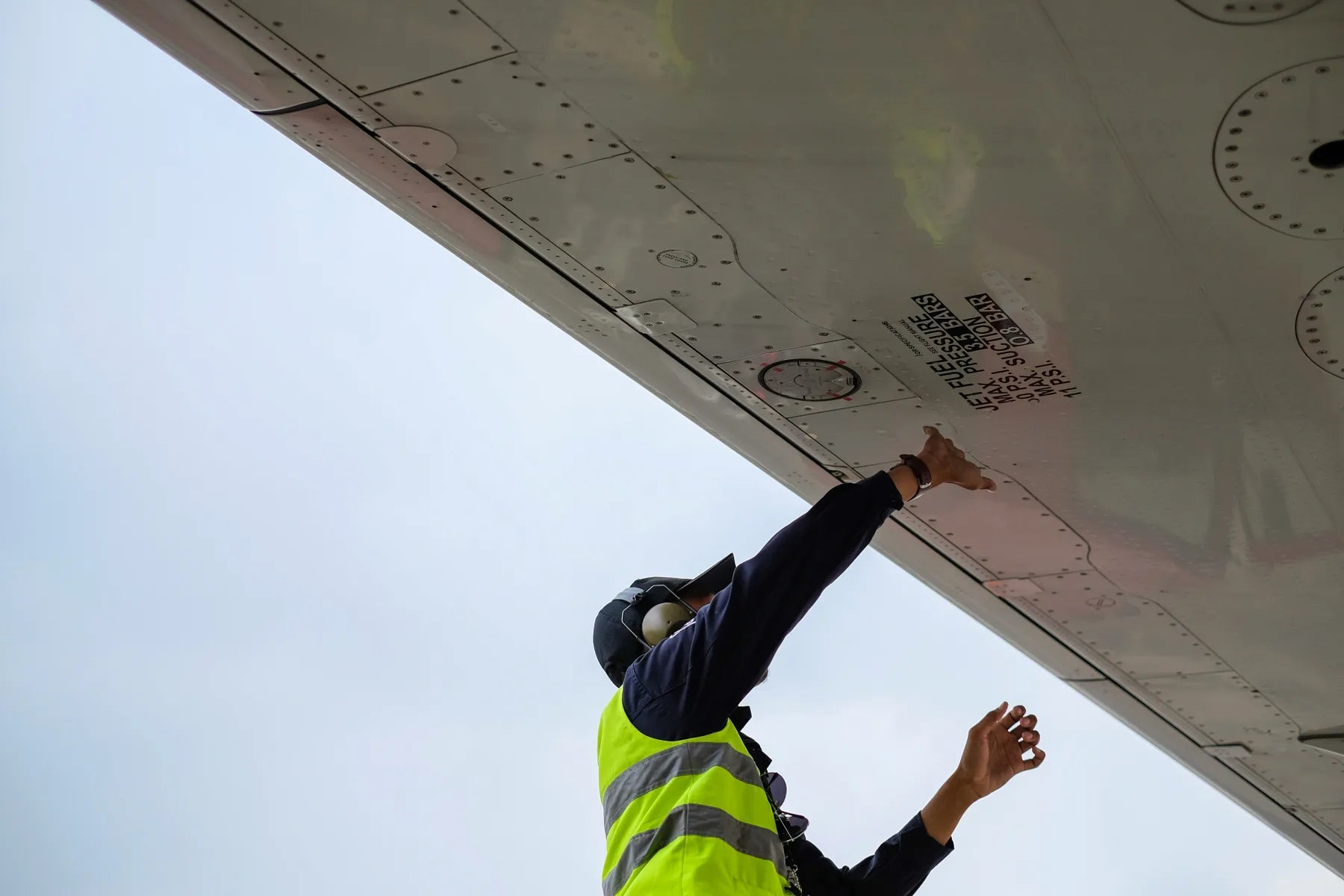 Aircraft mechanic inspecting a plane while wearing smart glasses.